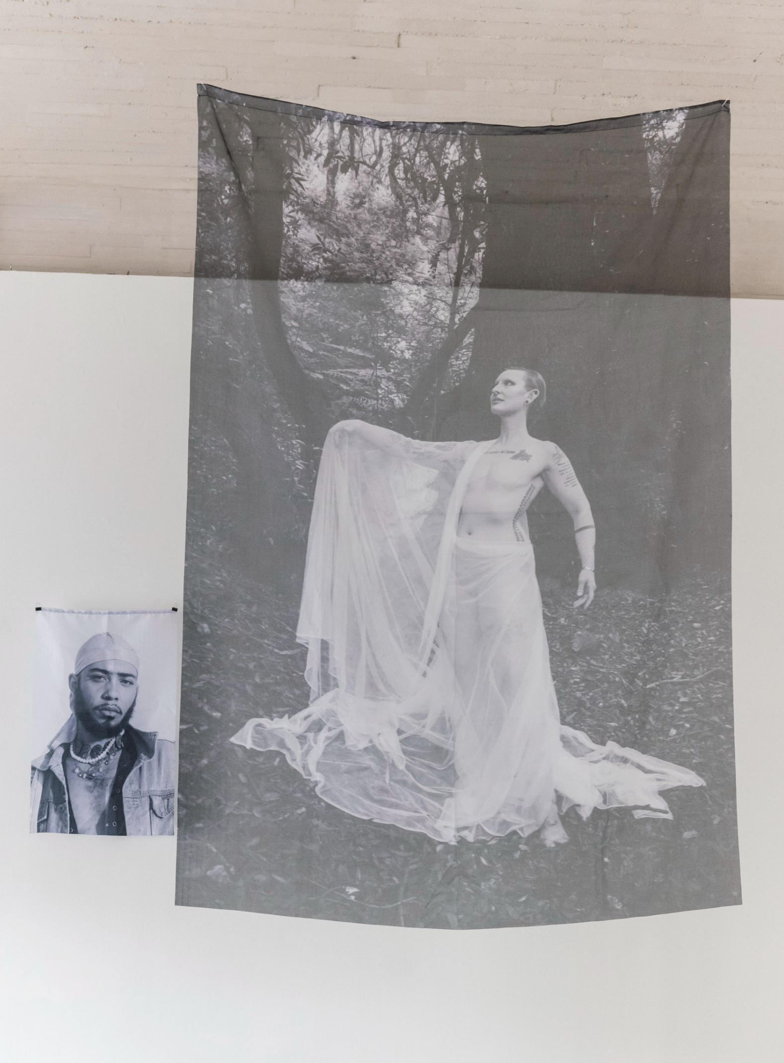 Portraits of Monte Nettles (large suspended cloth) and Cole Grey (smaller framed portrait), photographed in Oakland — sublimation on polyester, installed at MMACJS