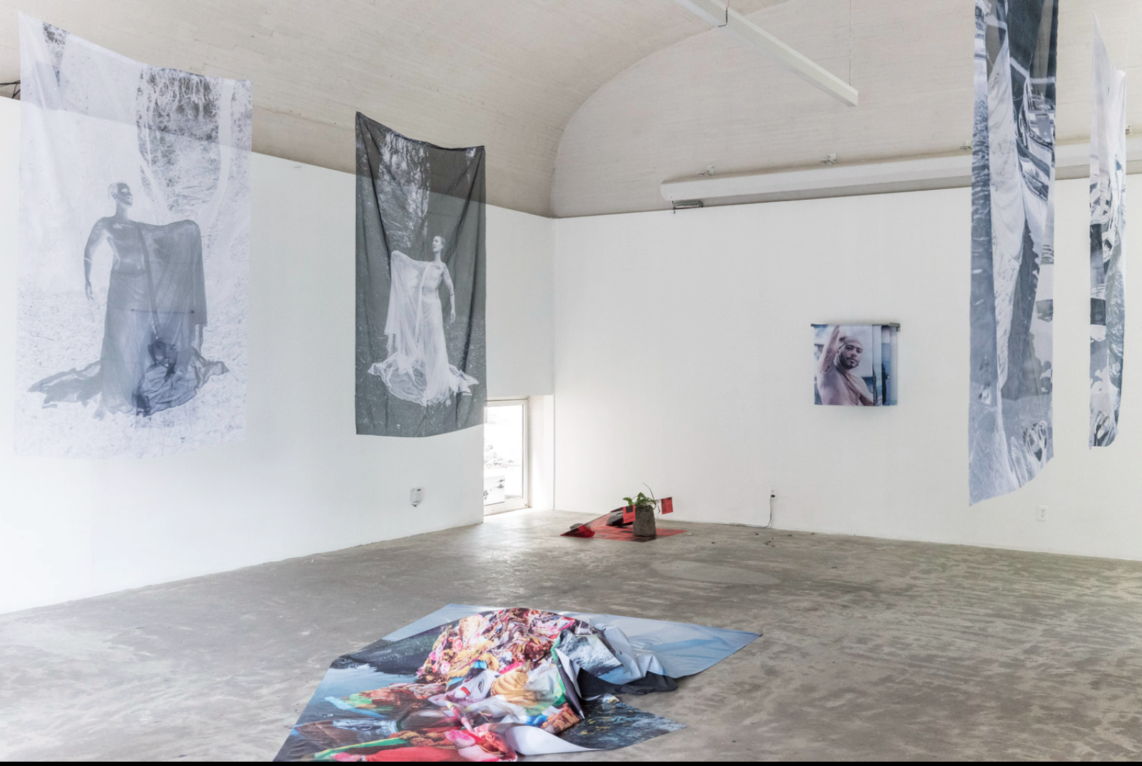 Installation view — sublimation cloths suspended from the ceiling with the Taj Mahal / Ganesh floor sculpture in the foreground, MMACJS