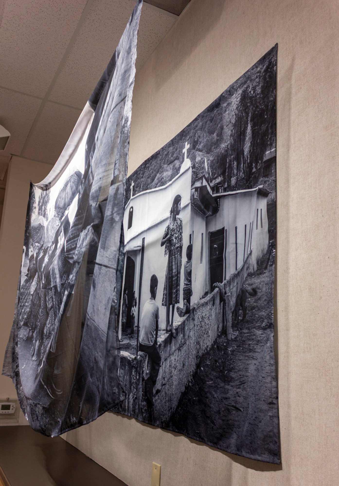 Installation, side view — two-layer sublimation on polyester at corner, showing matte ground fixed to wall and sheer front cloth hanging from ceiling