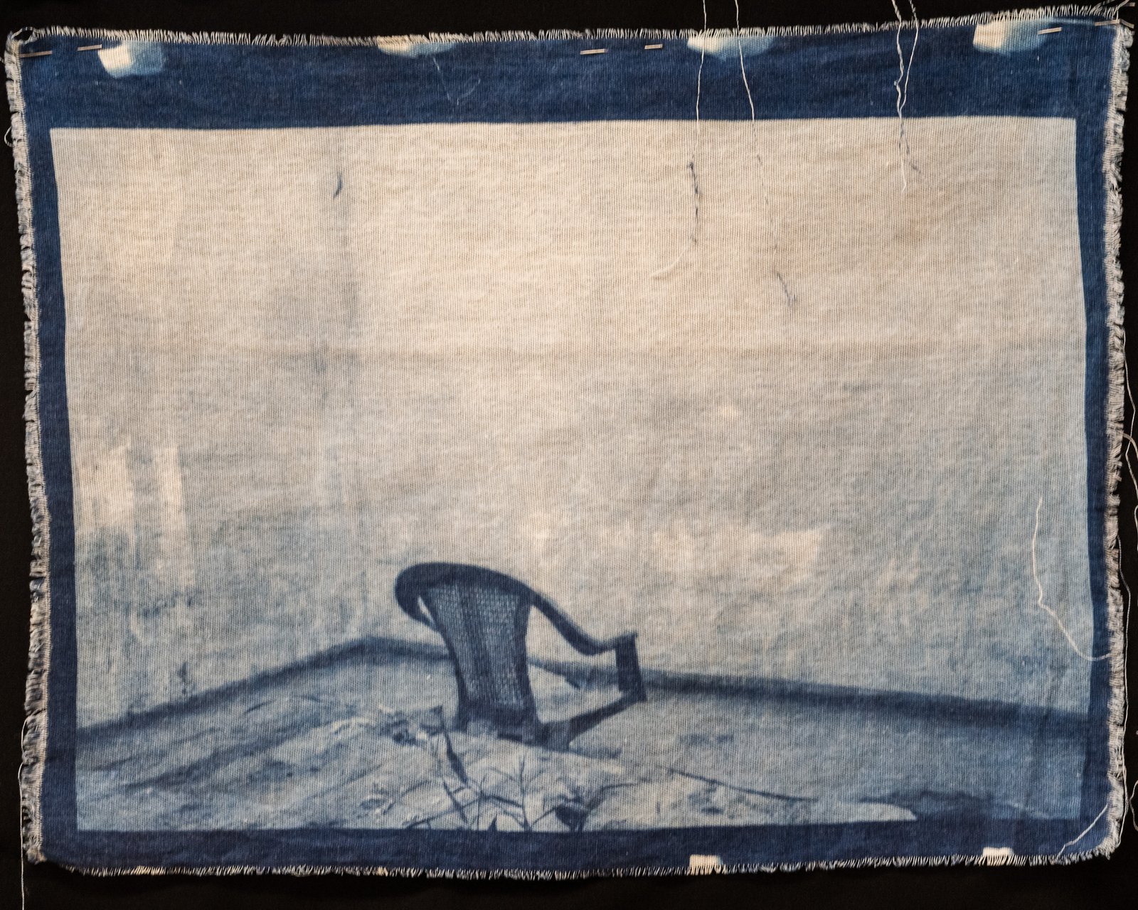 A broken chair on a dirt mound — cyanotype on cotton